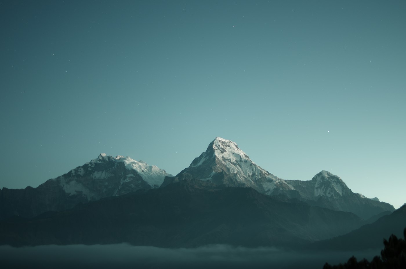 A range of snow-covered peaks in cool evening light